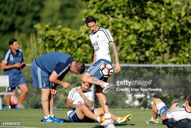 An injured Argentina midfielder Angel Di Maria juggles the ball as his teammates stretch out. Argentina practiced in advance of their quarterfinal...