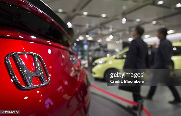 Visitors walk past a Honda Motor Co. NSX vehicle on display at the company's headquarters in Tokyo, Japan, on Monday, Oct. 31, 2016. Honda raised its...