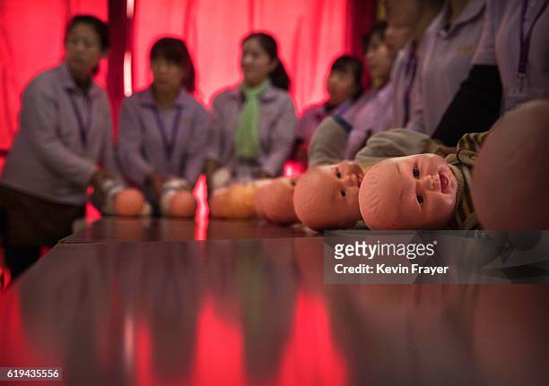 Plastic babies are seen on a table as Chinese women train to be qualified nannies, known in China as ayis, at the Ayi University on October 28, 2016...
