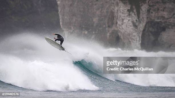 Professional surfer Al Mennie gets some air under the historic Dunluce Castle ruins on October 31, 2016 in Portrush, Northern Ireland. Built in the...