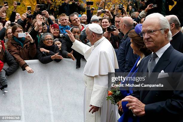 Pope Francis, Queen Silvia of Sweden and King Carl XVI Gustaf of Sweden greet spectators at Kungshuset on October 31, 2016 in Lund, Sweden. The Pope...