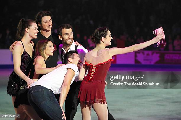 Evgenia Medvedeva of Russia takes selfie photographs with Partick Chan , Tessa Virtue , Scott Moir , Meagan Duhamel and Eric Radford of Canada at the...