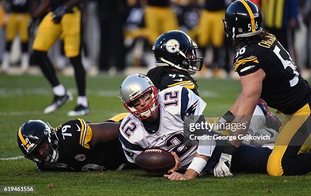 Quarterback Tom Brady of the New England Patriots looks up from the ground after he was tackled by defensive lineman Javon Hargrave and linebackers...