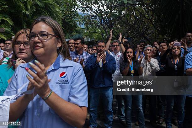 Empresas Polar SA employees applaud as the company's Chief Executive Officer Lorenzo Mendoza, not pictured, speaks during a news conference outside...