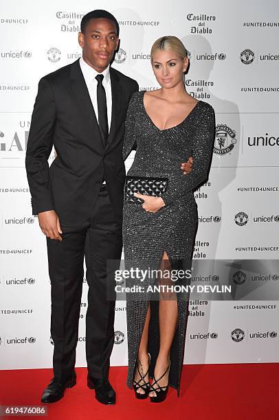 Manchester United's French striker Anthony Martial and partner Melanie da Cruz pose on the red carpet as they arrive to attend the "United for UNICEF...