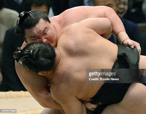Japan - Yokozuna Hakuho beats fellow Mongolian grand champion Harumafuji with an overarm throw on March 24 the final day of the Spring Grand Sumo...
