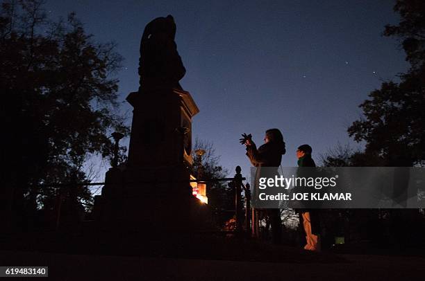 Visitor takes photographs of the memorial of Wolfgang Amadeus Mozart at Vienna's Central Cemetery on the eve of All Saints Day in Vienna, Austria on...