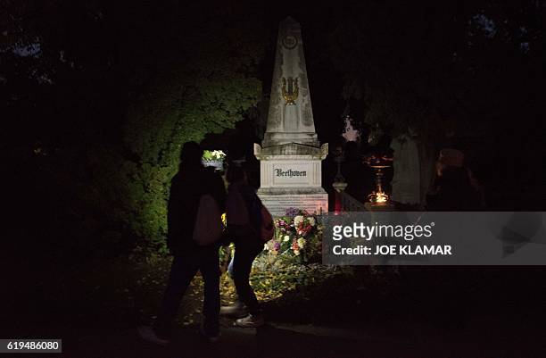 Visitors use mobile phones to illuminate the grave of famous German composer Ludwig van Beethoven at Vienna's Central Cemetery on the eve of All...