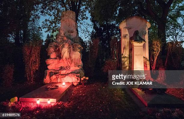Candles and flowers decorate a graves of composers Johann Strauss and Johannes Brahms at Vienna's Central Cemetery on the eve of All Saints Day in...