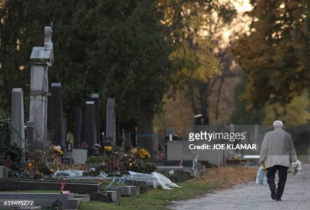 Man walks through Vienna's Central Cemetery on the eve of All Saints Day in Vienna, Austria on October 31, 2016. / AFP / JOE KLAMAR