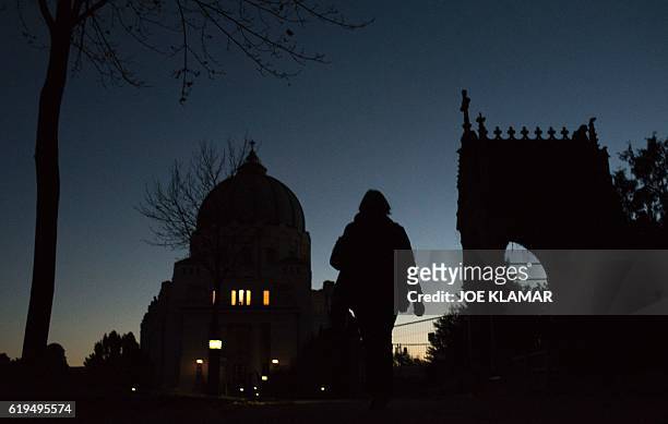 Woman walks through Vienna's Central Cemetery on the eve of All Saints Day in Vienna, Austria on October 31, 2016. / AFP / JOE KLAMAR