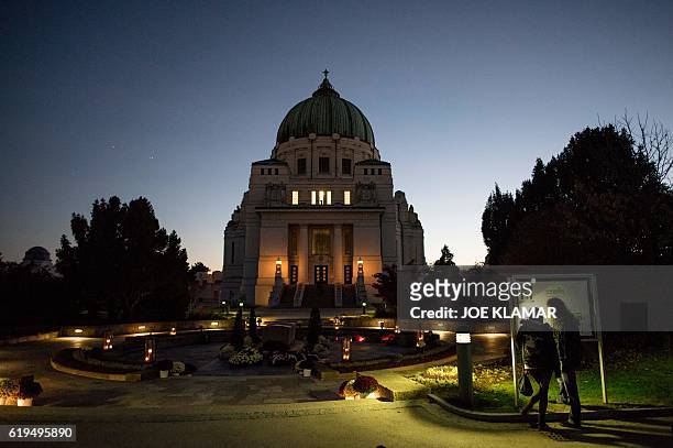 People look at the map of graves of Austrian Presidents buried in front of a Chapel at Vienna's Central Cemetery on the eve of All Saints Day in...
