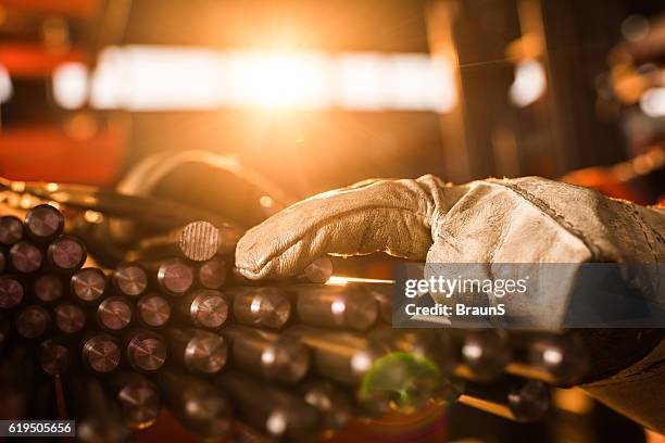 close up of unrecognizable worker with stack of metal tubes. - steel factory stock pictures, royalty-free photos & images