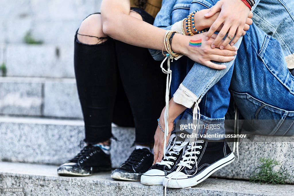 Unrecognizable girls embracing and sitting on stairs