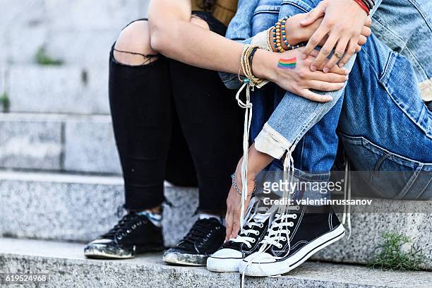 unrecognizable girls embracing and sitting on stairs - stiga stock pictures, royalty-free photos & images