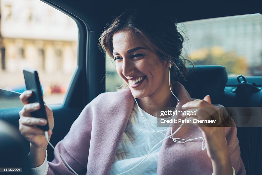 Woman with mobile phone in a car