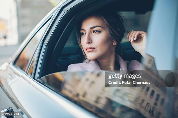 woman on the back seat of a car - society of peace stock pictures, royalty-free photos & images