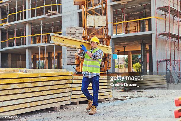 construction worker carrying planks - mason stock pictures, royalty-free photos & images