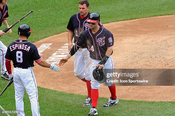 Washington Nationals right fielder Bryce Harper and first baseman Ryan Zimmerman are congratulated by shortstop Danny Espinosa after scoring against...