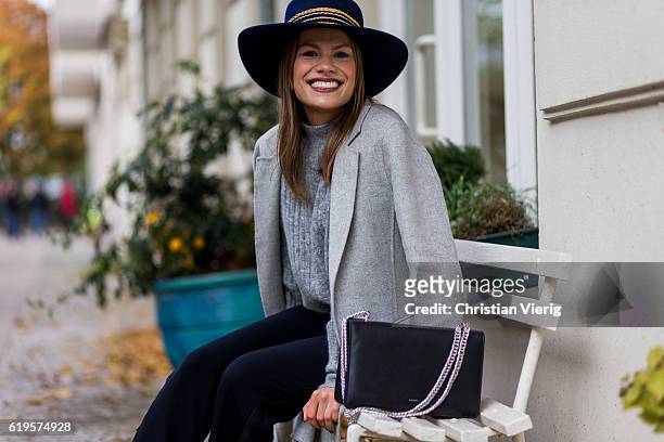 Julia Isabella Kuhne wears a grey ZARA wool coat, grey knitted jumper from H&M Trend, black pants ZARA, black bag Agneel, navy hat Ueterque on...