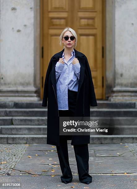 Leonie Markhorst wears a black coat COS, a blue white stripped button shirt from Avelon, black pants from Avelon, black pumps Zign , black sunglasses...