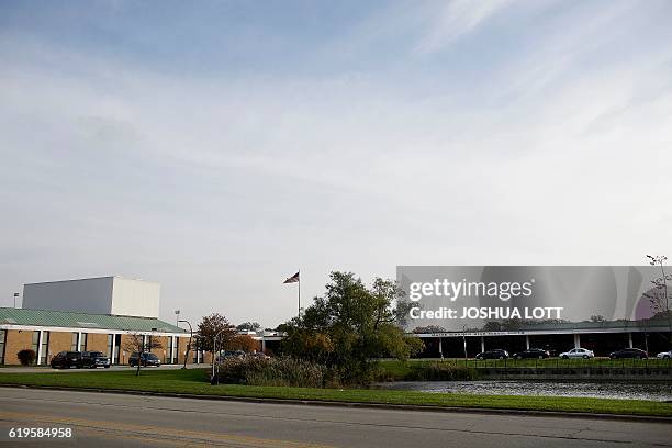 Vehicles are parked outside Maine Township High School South where Democratic presidential nominee Hillary Clinton attended classes on October 28,...