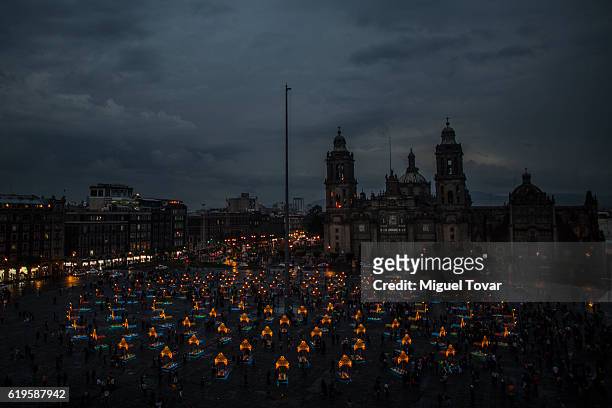 People walk arround representations of boats known as trajineras displayed as part of the Day of the Dead celebrations at Mexico City's Zocalo main...