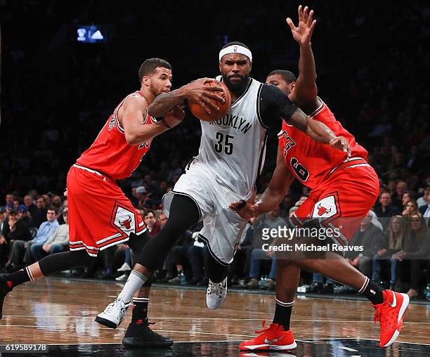 Trevor Booker of the Brooklyn Nets drives to the basket past Michael Carter-Williams and Cristiano Felicio of the Chicago Bulls during the first half...