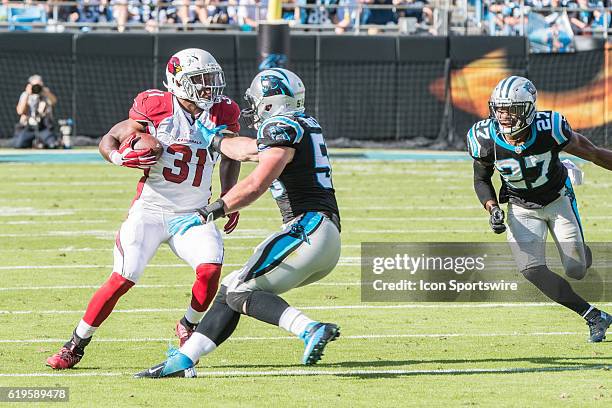 Arizona Cardinals running back David Johnson carries the ball as Carolina Panthers Linebacker Luke Kuechly and Carolina Panthers Cornerback Robert...