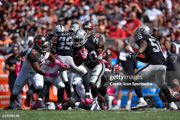 Oakland Raiders Running Back Jalen Richard looks to avoid Tampa Bay Buccaneers Linebacker Cameron Lynch during an NFL football game between the...