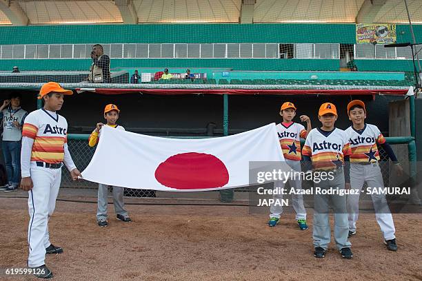 Kids hold Japan's flag prior the WBSC U-23 Baseball World Cup Group B game between Austria and Japan at Estadio de Beisbol Francisco I. Madero on...