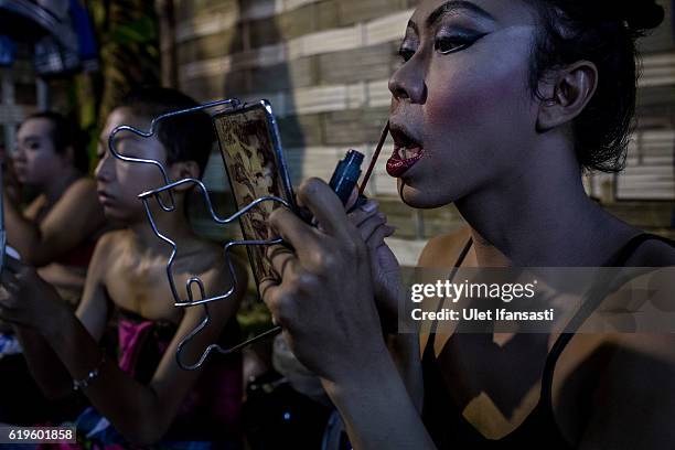 Transvestite Arimbi , applies make-up in the backstage before performing a traditional dance opera known as Ludruk on October 29, 2016 in Surabaya,...