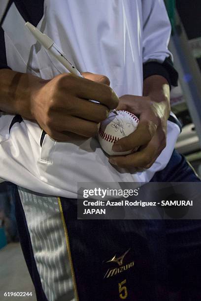 Taishi Hirooka of Japan signs a ball at the end of the WBSC U-23 Baseball World Cup Group B game between Austria and Japan at Estadio de Beisbol...