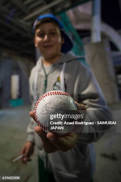Fan of Japan shows a ball signed by Japan's players and coaches after the WBSC U-23 Baseball World Cup Group B game between Austria and Japan at...