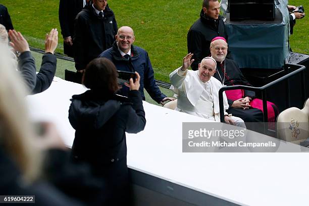 Pope Francis and Sweden's Catholic bishop Anders Arborelius greet participants as he arrives for the Holy Mass at the Swedbank Stadion on November 1,...