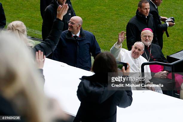 Pope Francis and Sweden's Catholic bishop Anders Arborelius greet participants as he arrives for the Holy Mass at the Swedbank Stadion on November 1,...