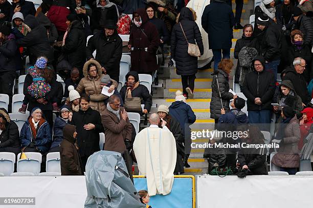 Priests walk into the crowd to administer Communion during the Holy Mass with Pope Francis at the Swedbank Stadion on November 1, 2016 in Malmo,...