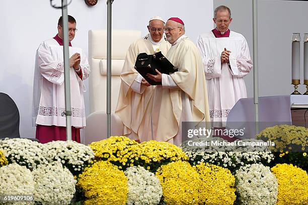 Pope Francis hands over a gift to Sweden's Catholic bishop Anders Arborelius during the Holy Mass at the Swedbank Stadion on November 1, 2016 in...