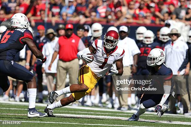 Wide receiver Darreus Rogers of the USC Trojans is tackled by safety Demetrius Flannigan-Fowles and cornerback Jace Whittaker of the Arizona Wildcats...