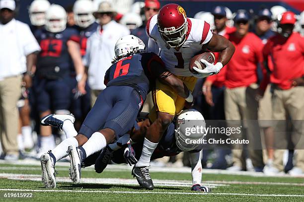 Wide receiver Darreus Rogers of the USC Trojans is tackled by safety Demetrius Flannigan-Fowles and cornerback Jace Whittaker of the Arizona Wildcats...