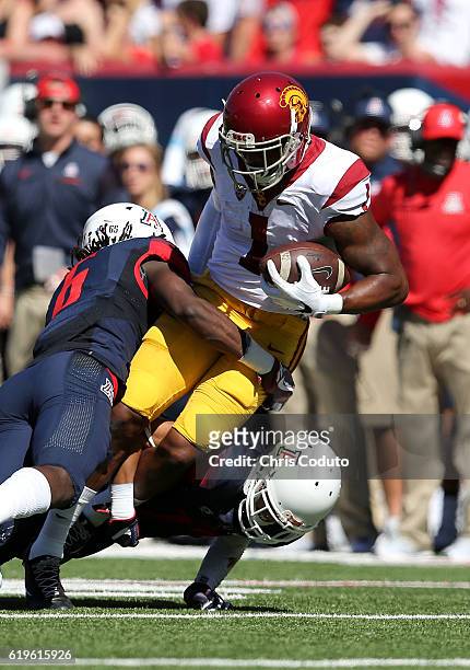 Wide receiver Darreus Rogers of the USC Trojans is tackled by safety Demetrius Flannigan-Fowles and cornerback Jace Whittaker of the Arizona Wildcats...