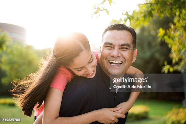 Playful latin father and teen daughter laughing