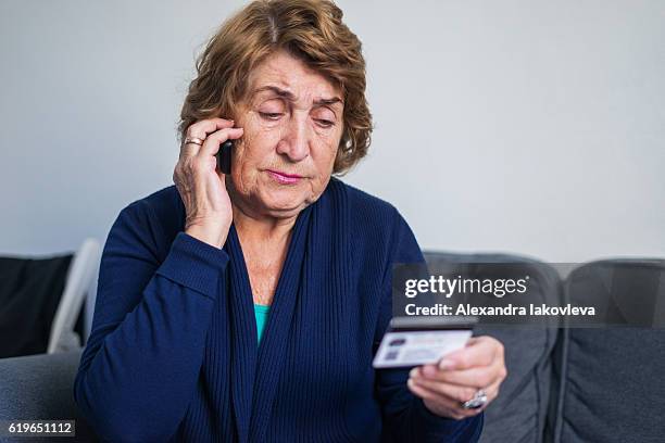 senior woman using mobile phone while holding credit card - corporate theft 個照片及圖片檔