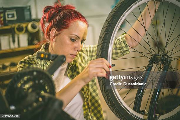 bicycle mechanic repairing on bike in a workshop - women motorsport stock pictures, royalty-free photos & images