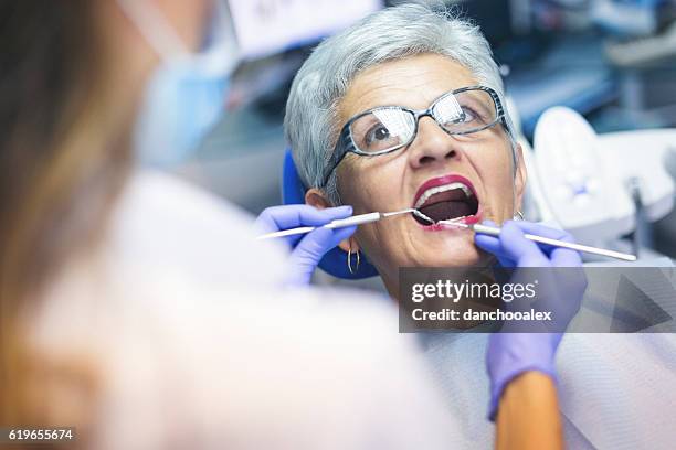 senior female patient at dentist office - dental filling stockfoto's en -beelden