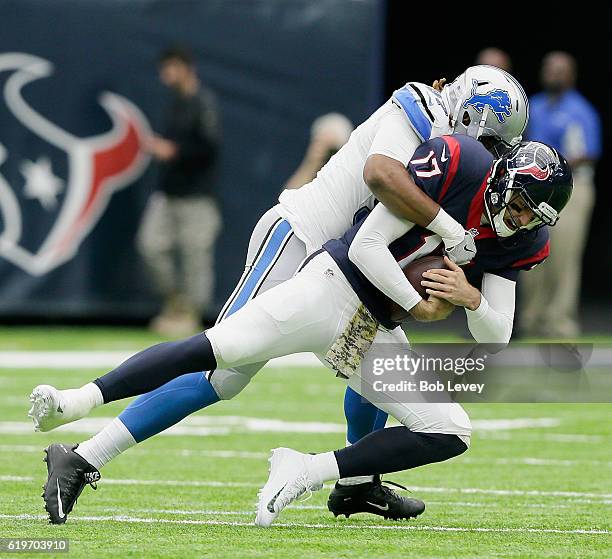 Brock Osweiler of the Houston Texans flinches as he is sacked by Armonty Bryant of the Detroit Lions at NRG Stadium on October 30, 2016 in Houston,...