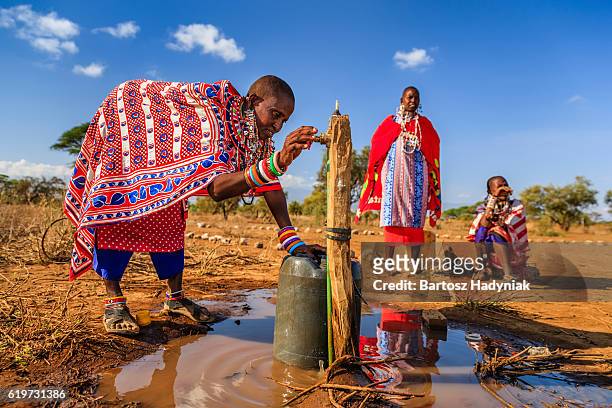 african woman from maasai tribe collecting water, kenya, east africa - african village bildbanksfoton och bilder
