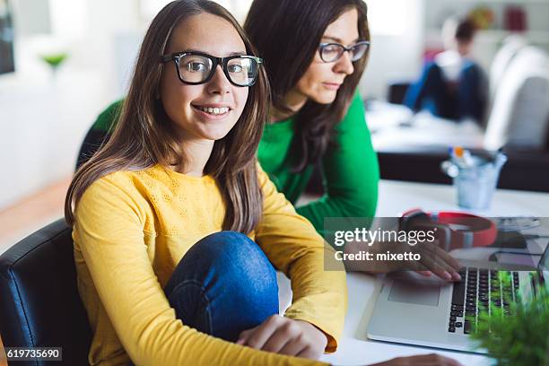 young girl with mother doing homework on the lap top - day stock pictures, royalty-free photos & images