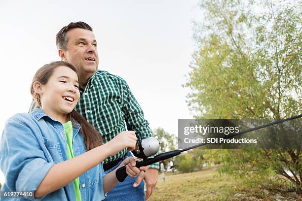 ragazza felice pesca con il nonno - fishing reel foto e immagini stock