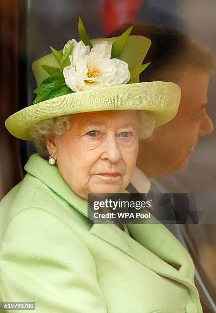 Queen Elizabeth II rides a carriage with Colombia's President Juan Manuel Santos as they depart his ceremonial welcome at Horse Guards Parade on...